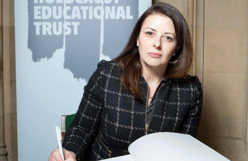 Joy signing the Book of Commitment