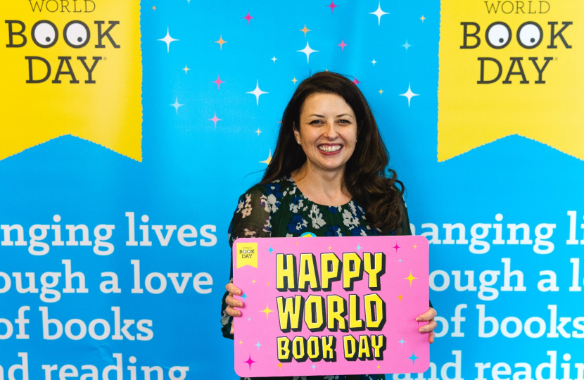 Joy on World Book Day holding sign.